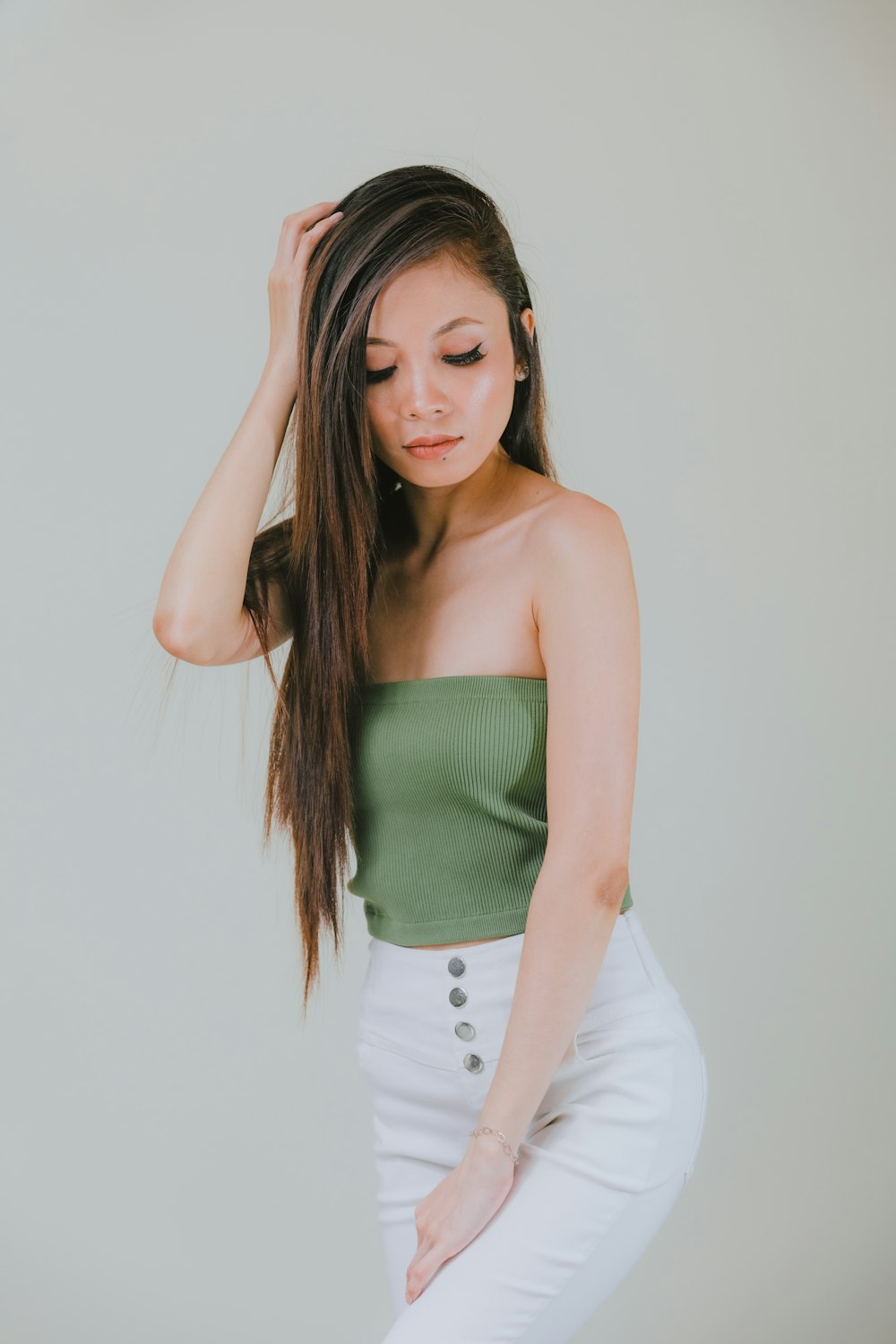 a woman in white pants and a green top