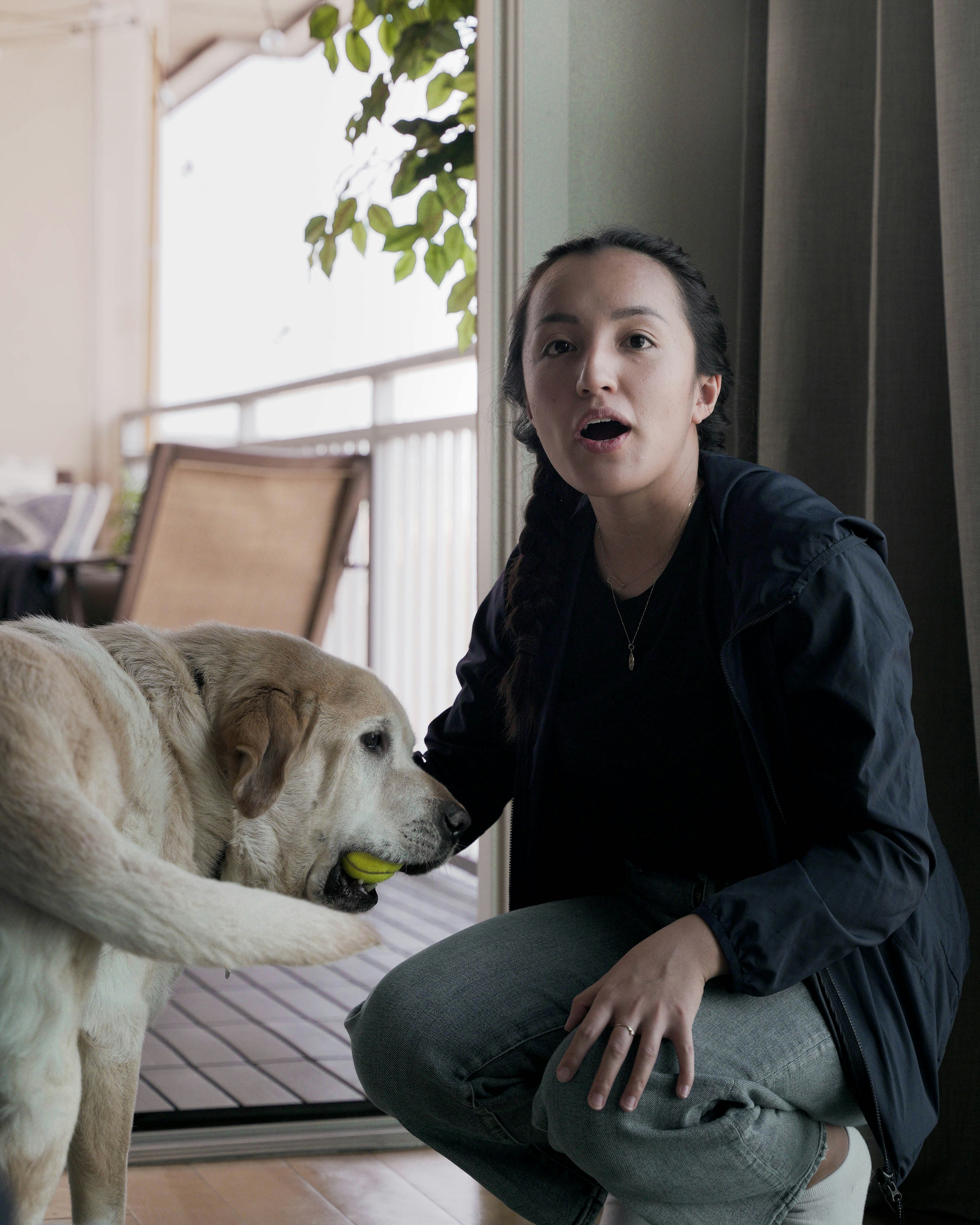a woman kneeling down with a dog on her lap