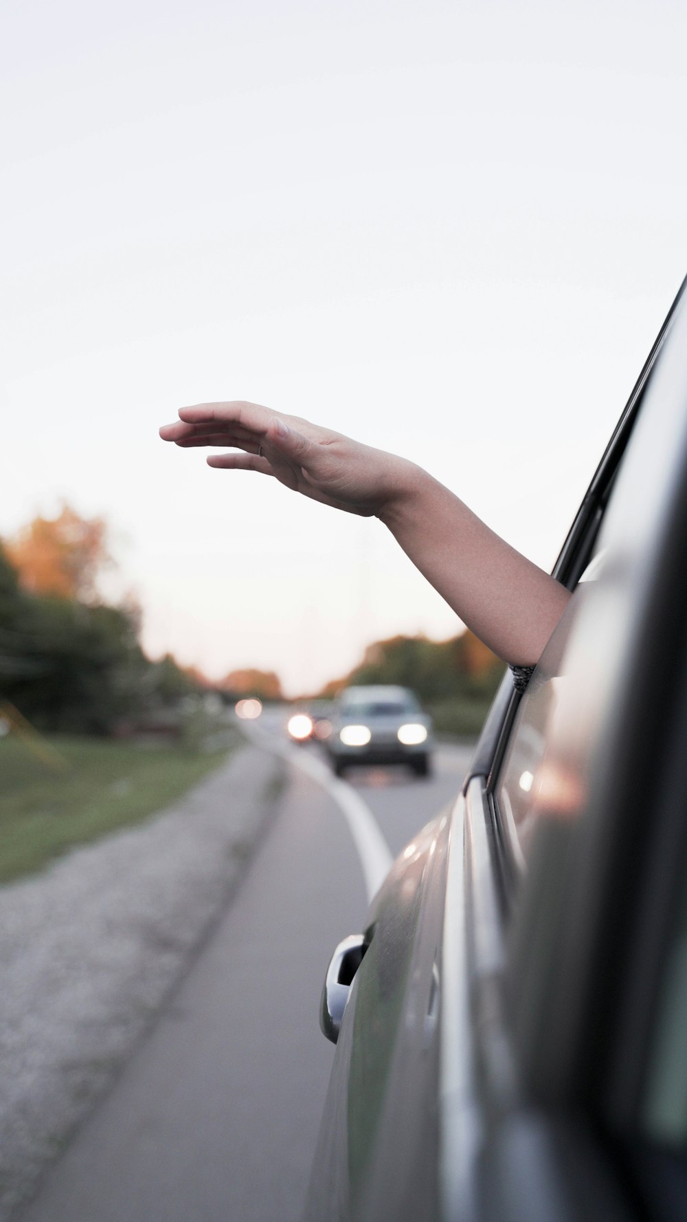 une main tendue par la fenêtre d’une voiture