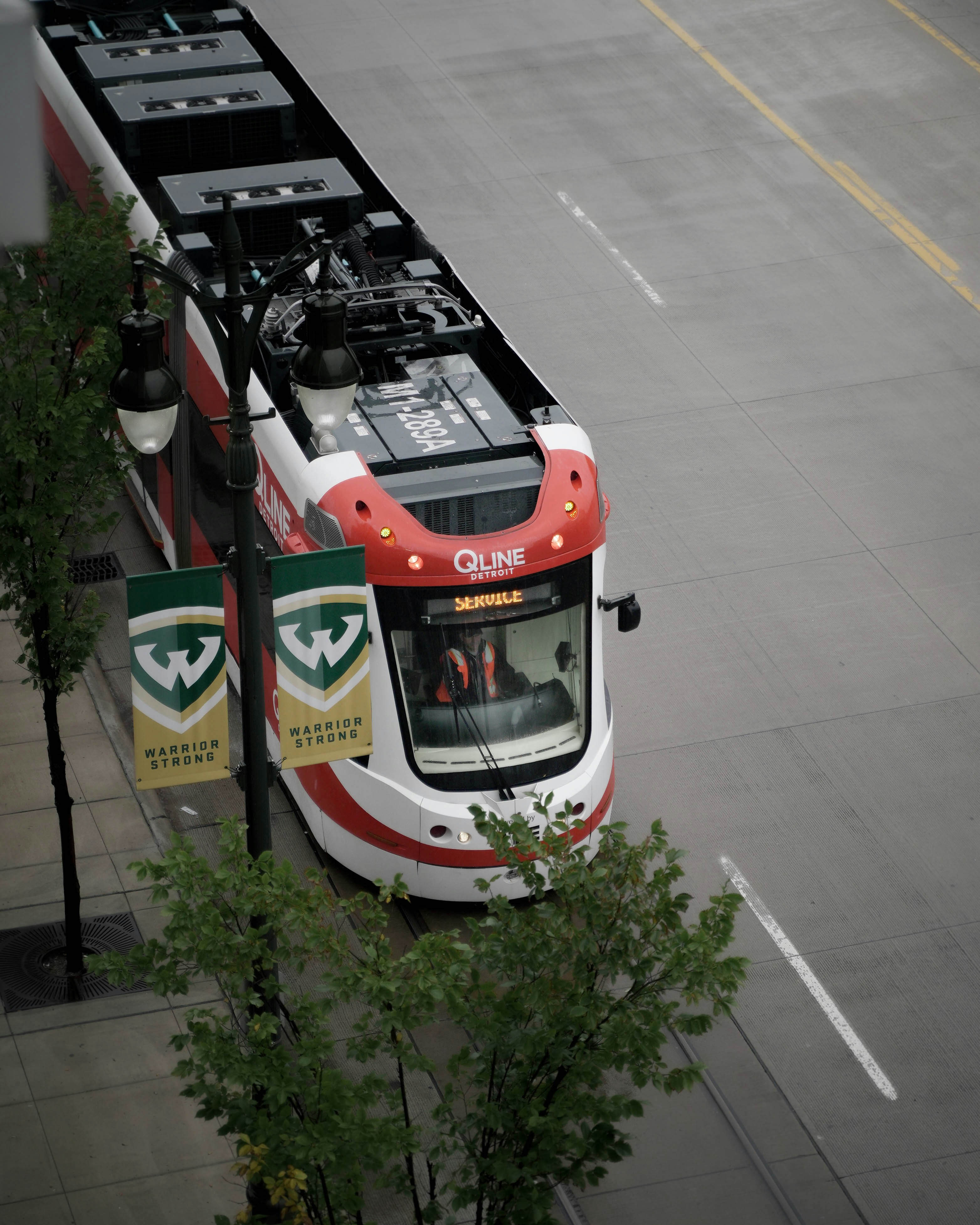 a red and white bus driving down a street