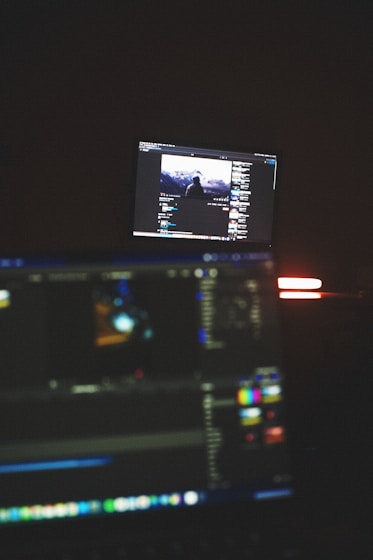 Portrait of Abdelrahman Khairy working at his video editing station with dual monitors and warm lighting.