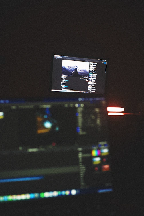 A sleek editing suite with multiple screens showing video and photo editing software.