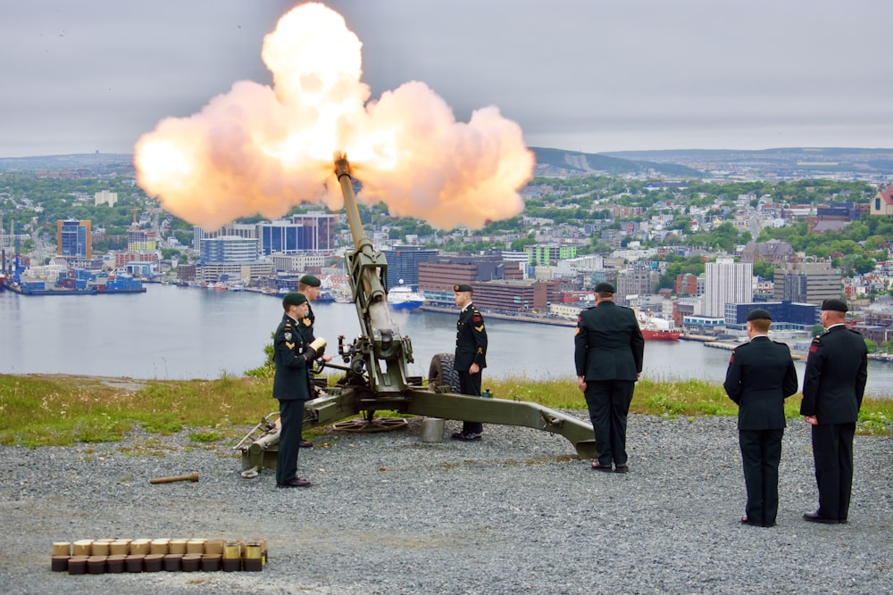 a group of men standing next to a cannon