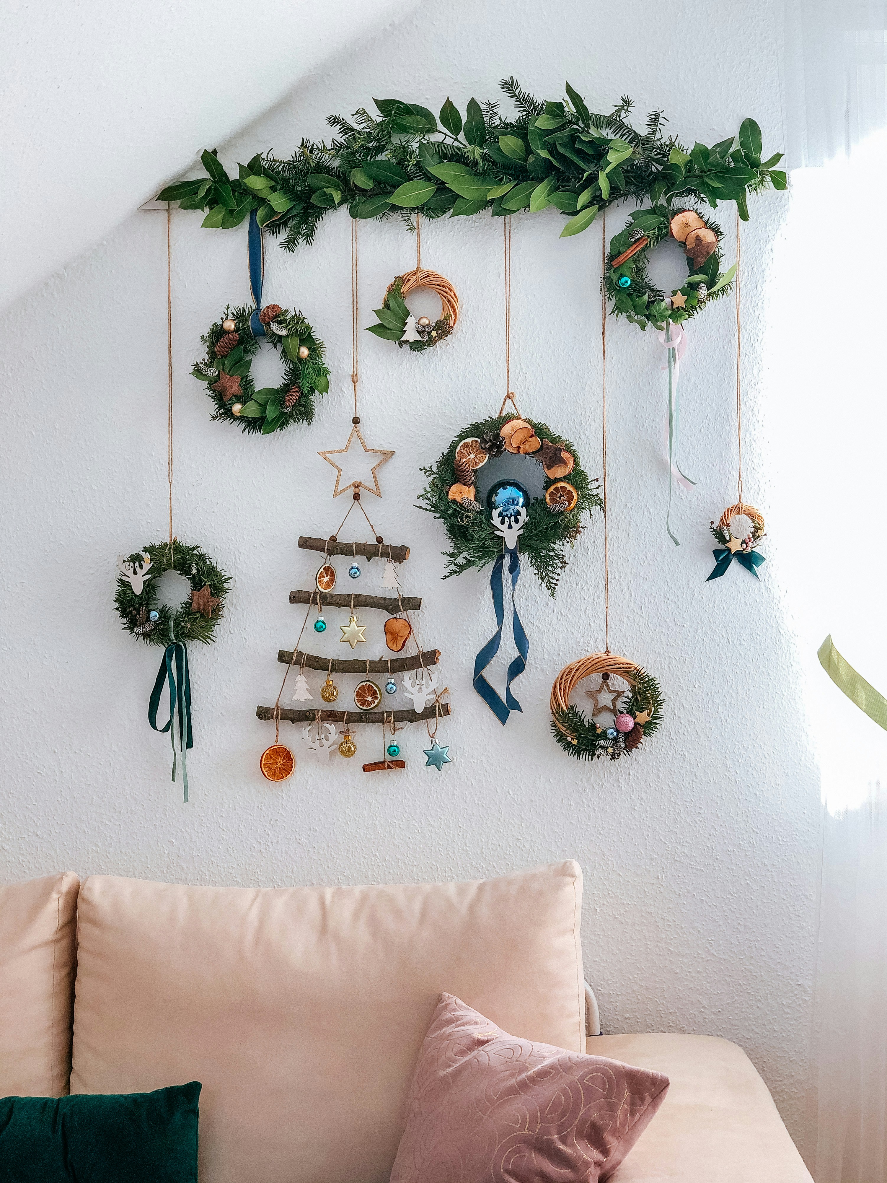 a living room with a couch and a christmas tree hanging on the wall