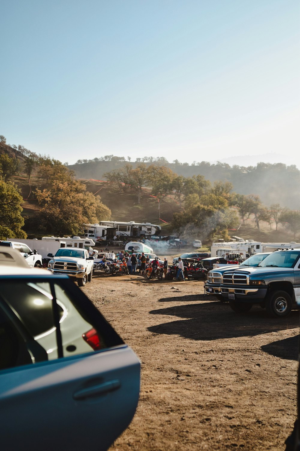 a group of trucks parked next to each other on a dirt field