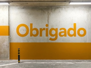 a yellow and white sign that reads obrigado