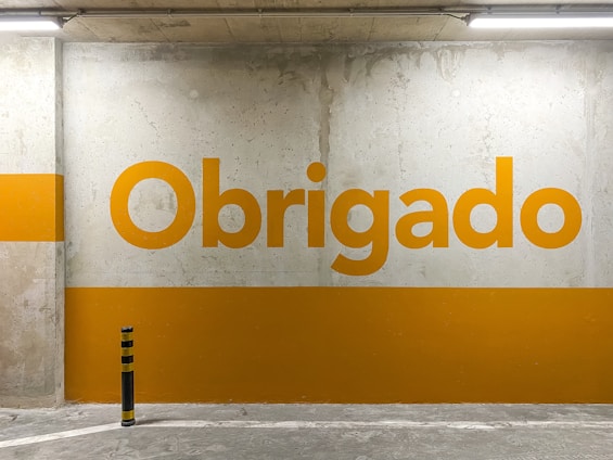 a yellow and white sign that reads obrigado
