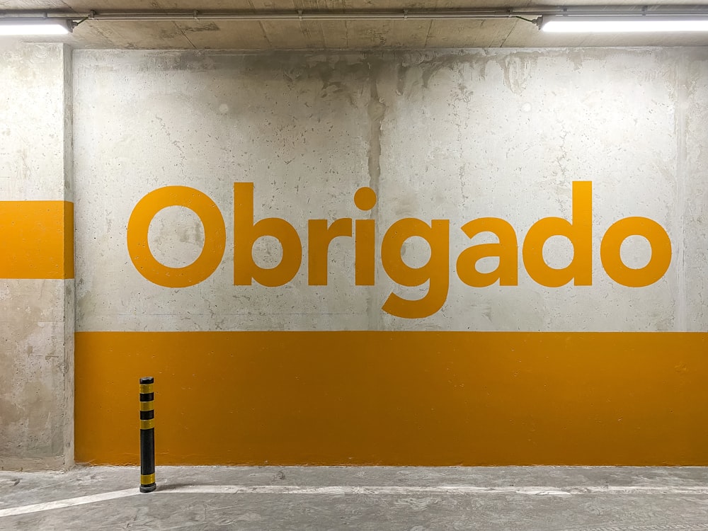 a yellow and white sign that reads obrigado