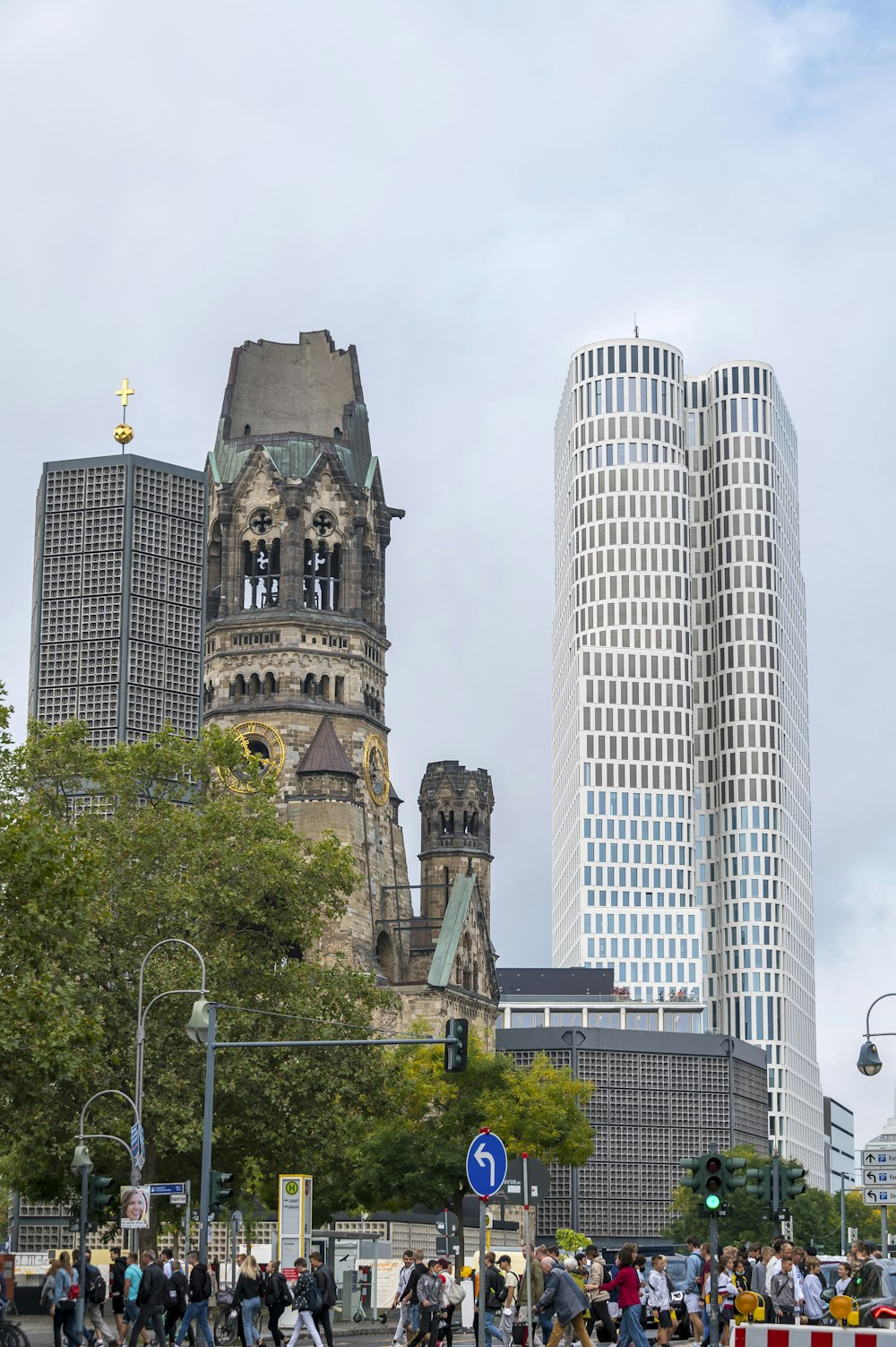 a group of people walking down a street next to tall buildings