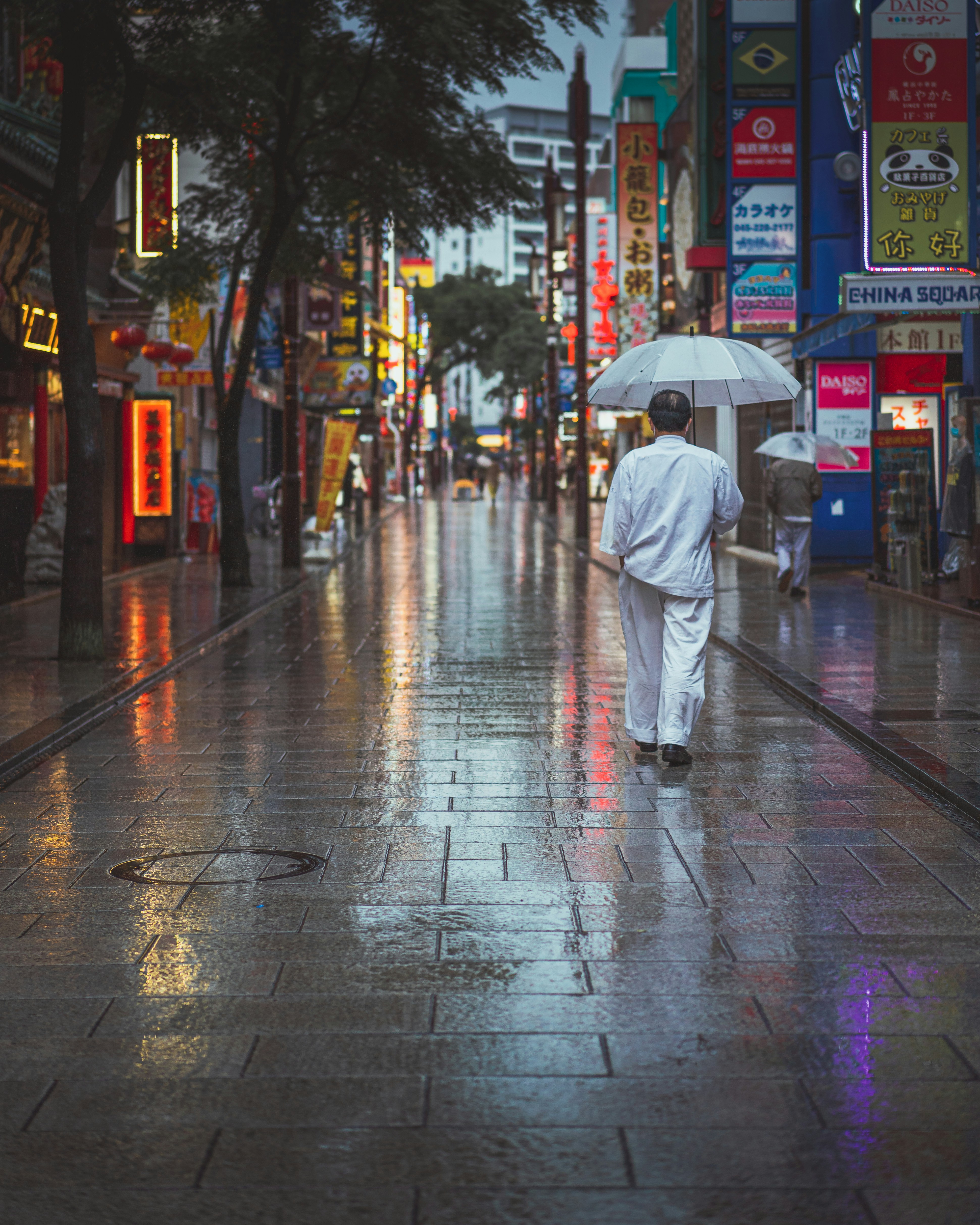 a man walking down a street holding an umbrella