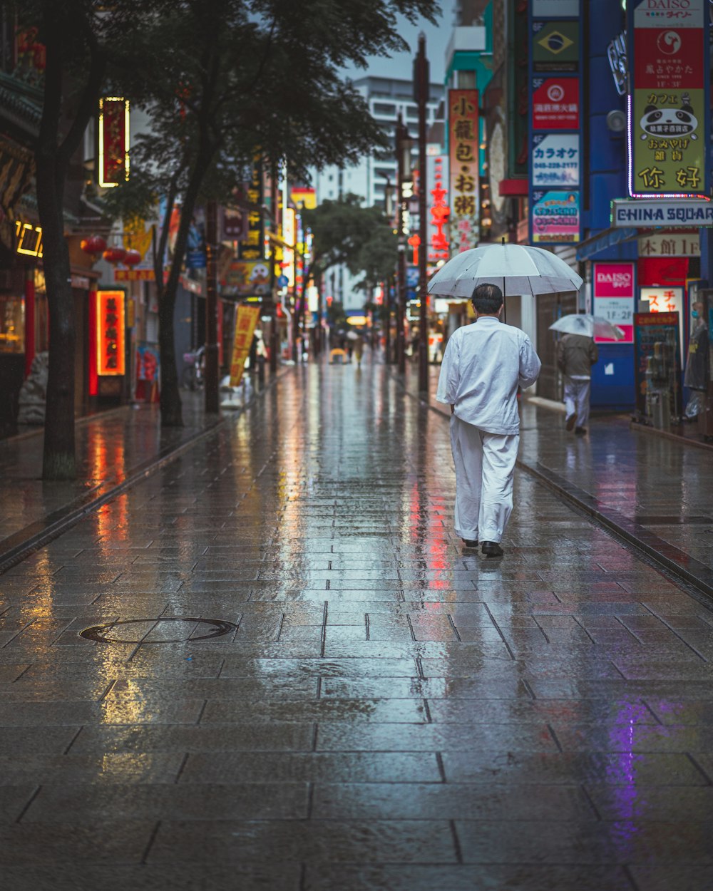 a man walking down a street holding an umbrella