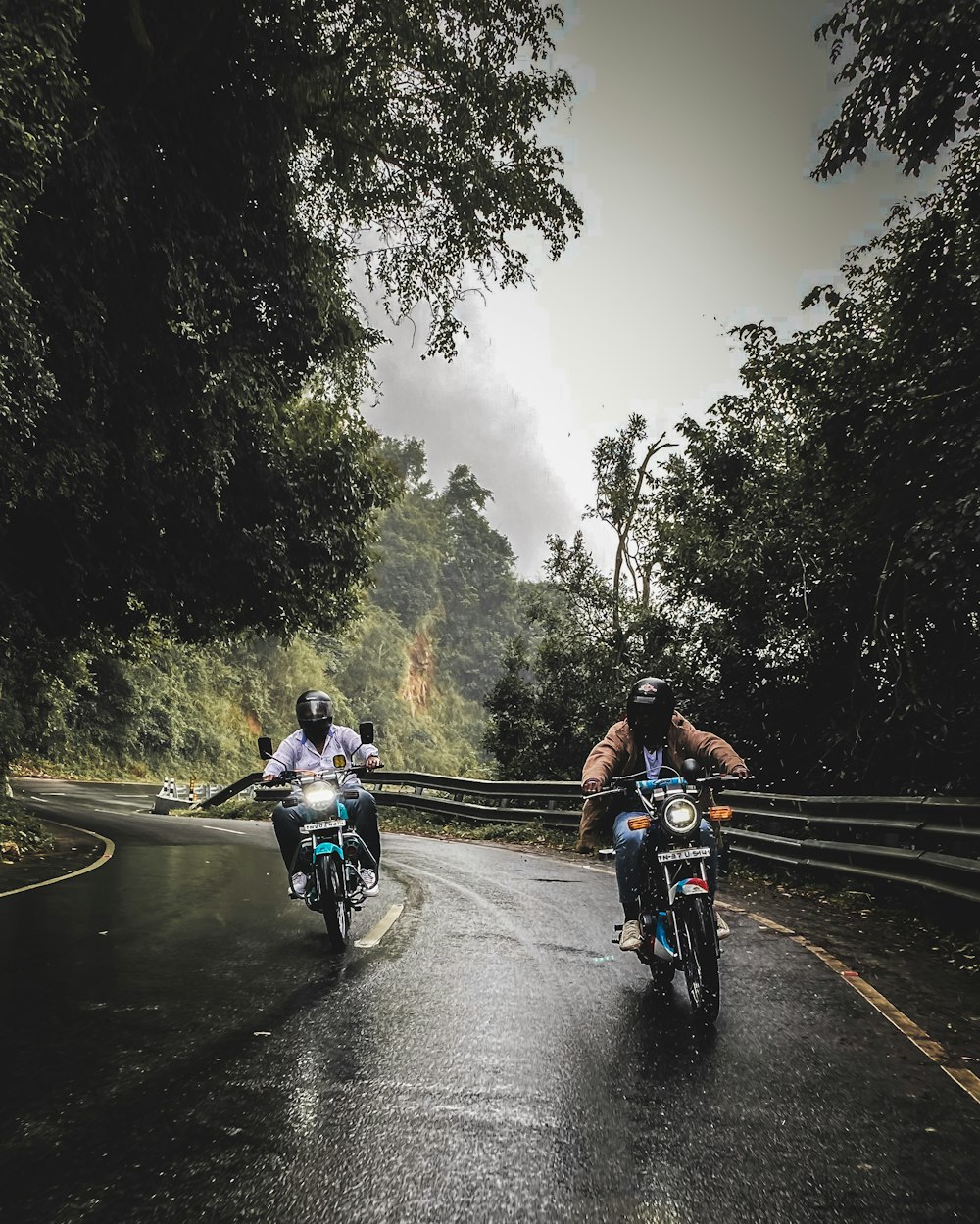 deux personnes à moto sur une route mouillée