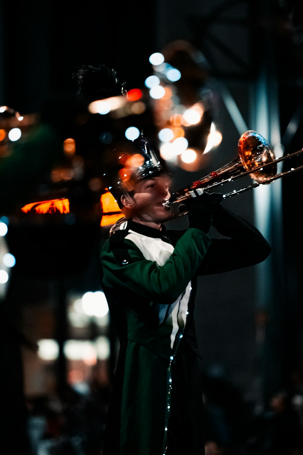 a man in a green coat playing a trombone