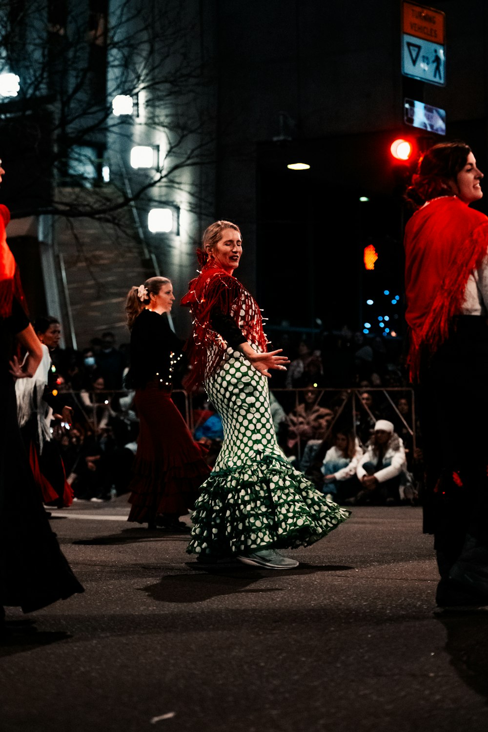 a group of people walking down a street at night