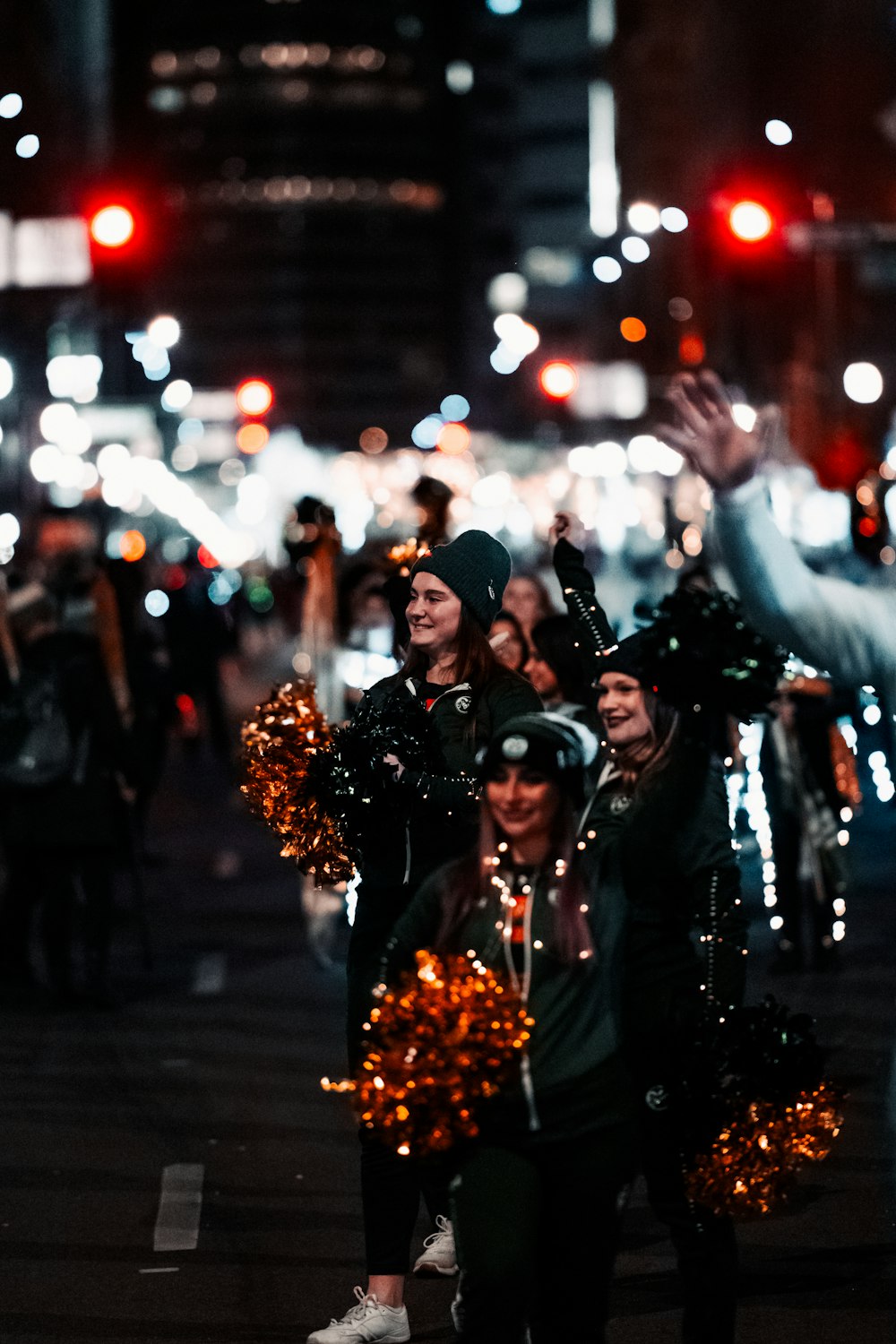 a group of people walking down a street at night