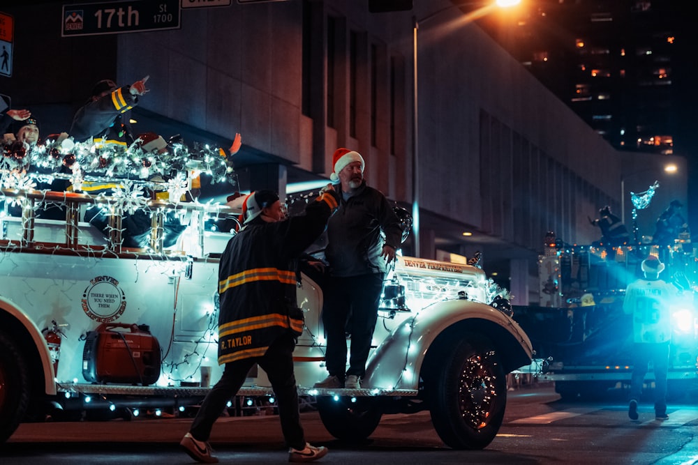 a group of people standing on the back of a fire truck