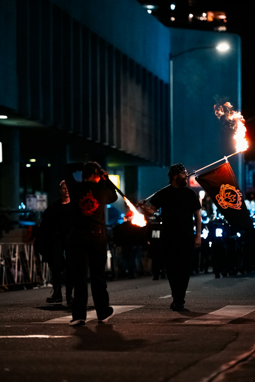 a group of people walking down a street holding torches