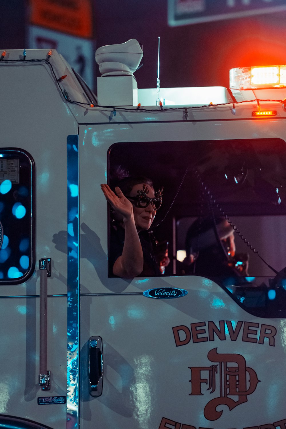 a woman waving out the window of a fire truck