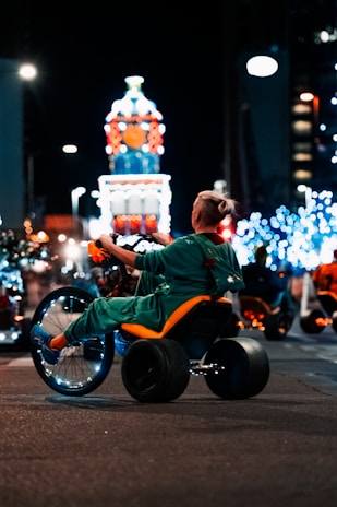 a man in a wheel chair rides down the street