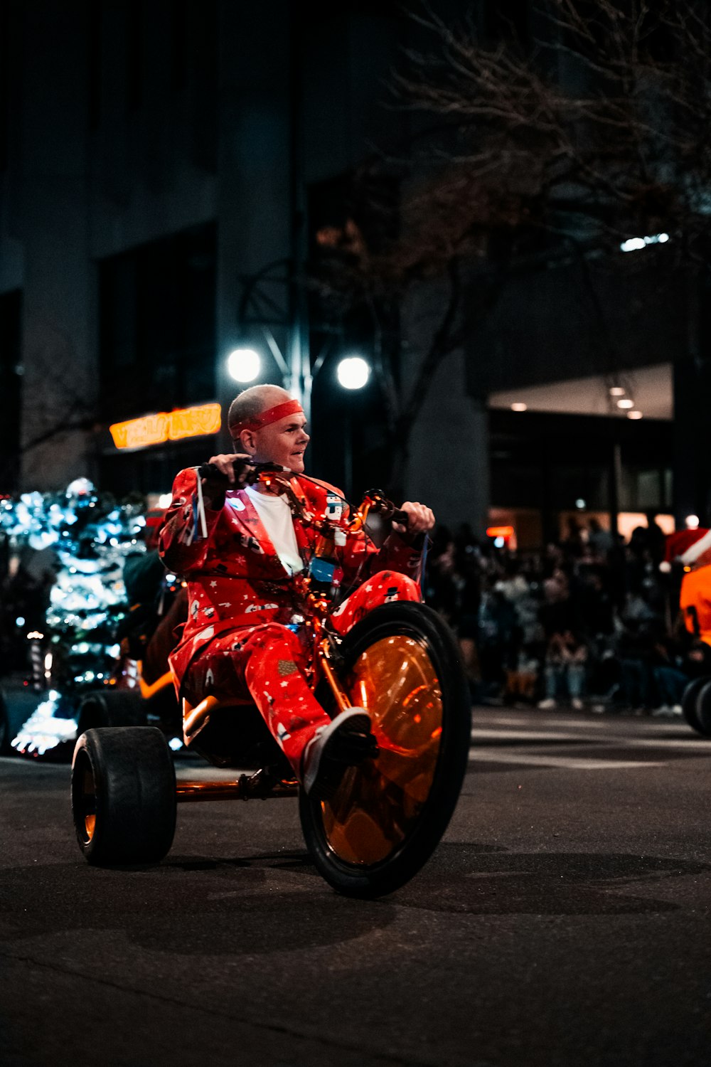 ピエロのスーツを着た男が通りをバイクに乗る