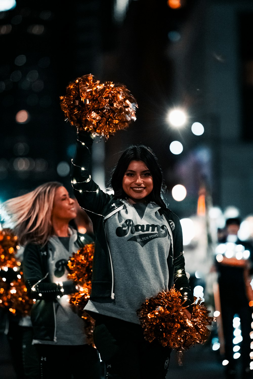 two cheerleaders walking down the street at night