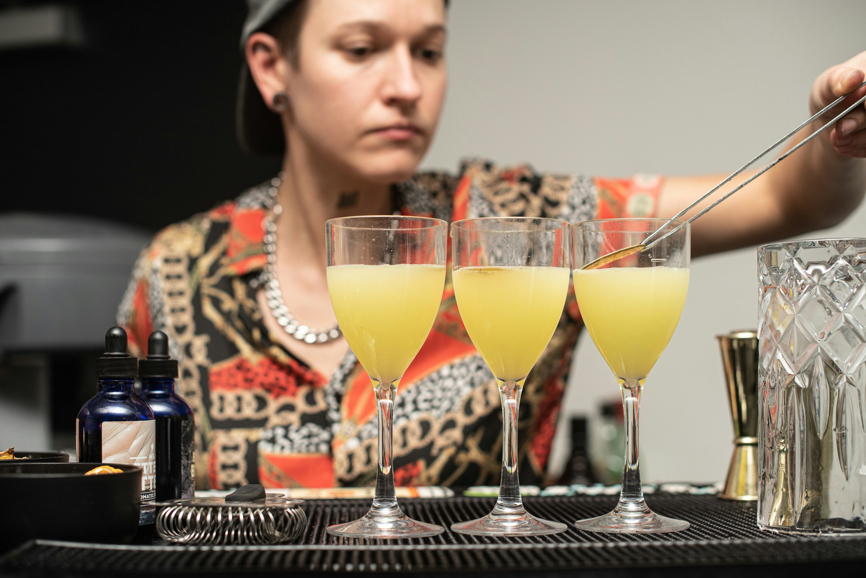 Bartender with three yellow cocktails
