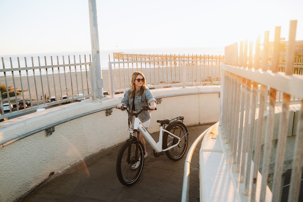 Una mujer parada junto a una bicicleta en un balcón