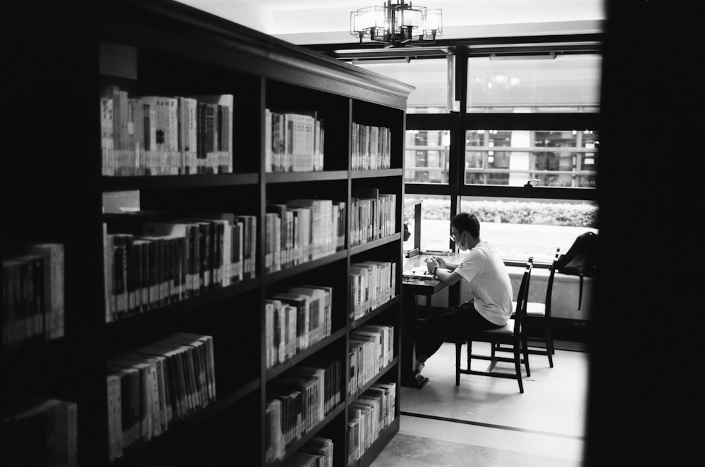 a person sitting at a table in a library