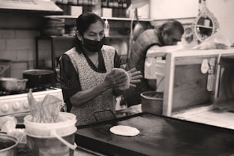 An industrial kitchen with automated machinery preparing tortillas.