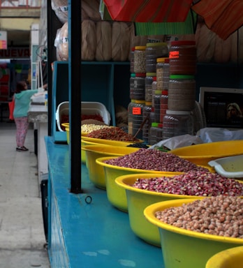 A friendly customer service representative answering calls with a backdrop of stacked crates of pulses and cereals.