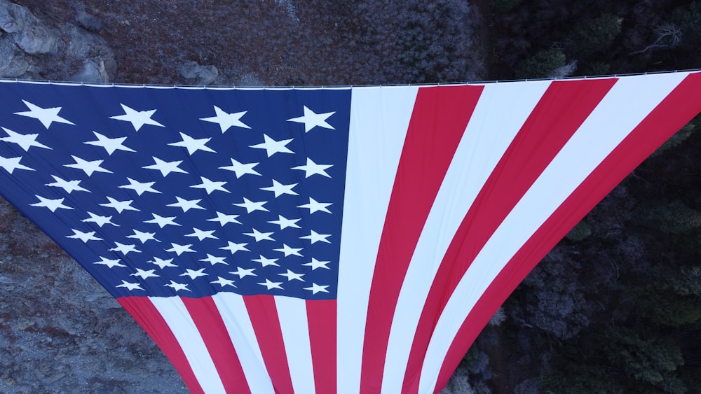 a large american flag hanging from a stone wall