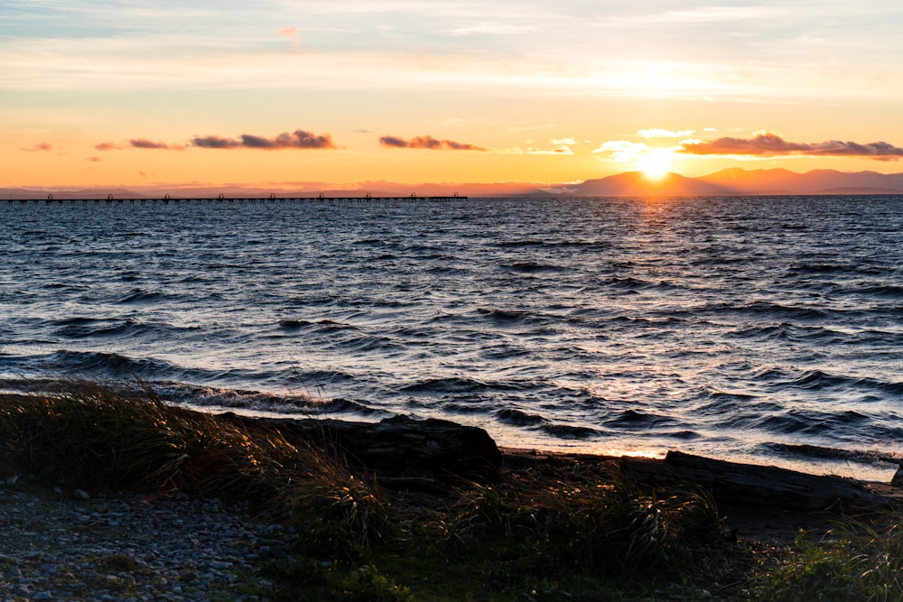 the sun is setting over a body of water