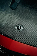 Close-up of a carbon fiber hood with sleek metallic silver finish under soft lighting.