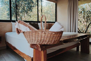 a wicker basket sitting on top of a bed