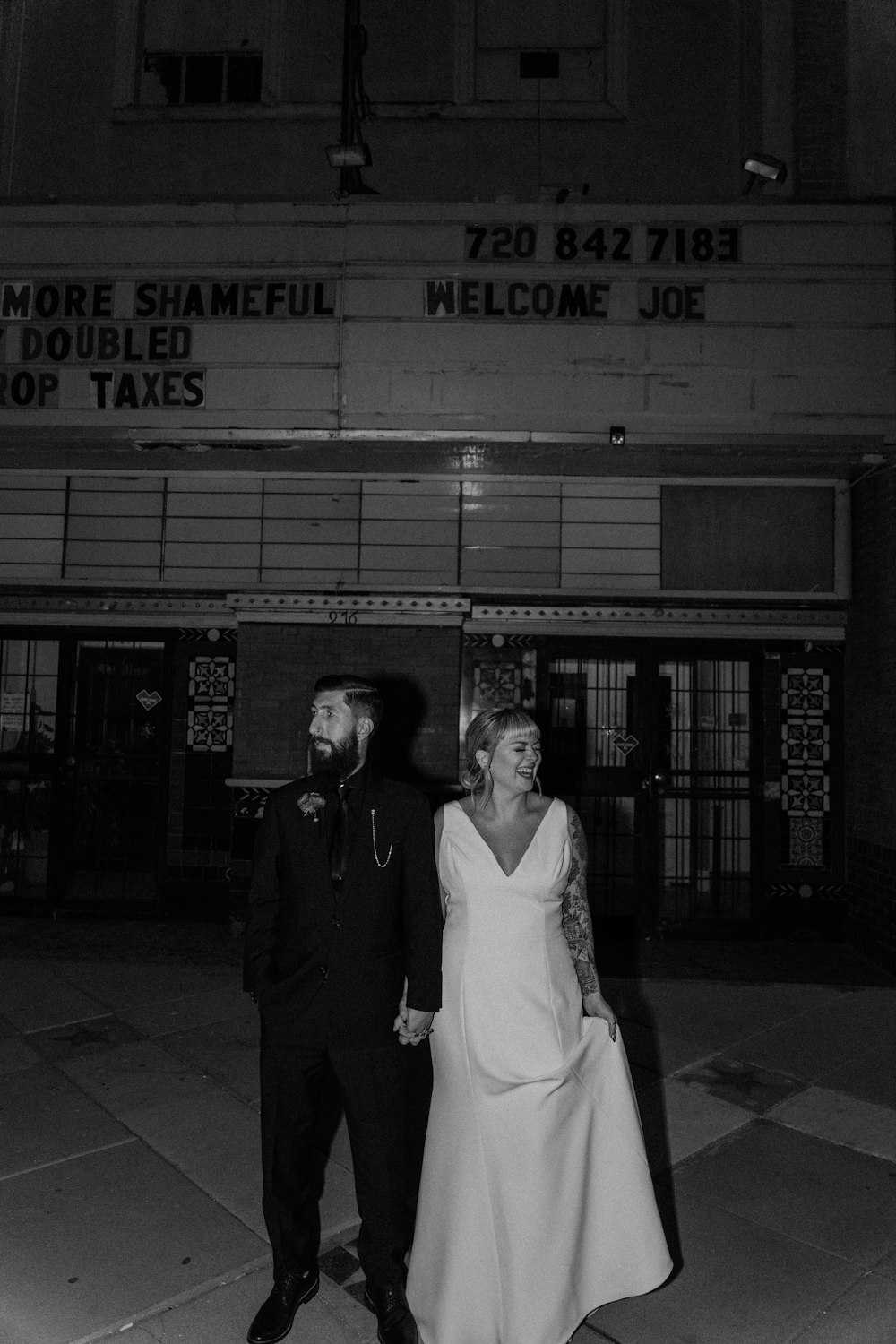 a man and a woman standing in front of a movie theater