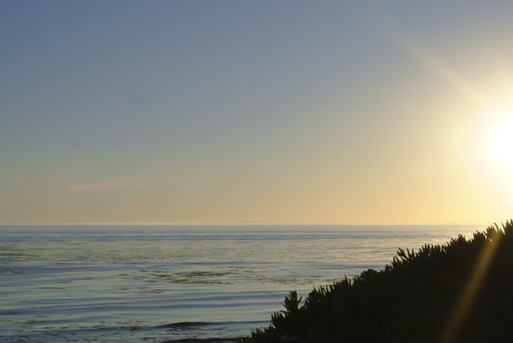 the sun is setting over the ocean on a clear day