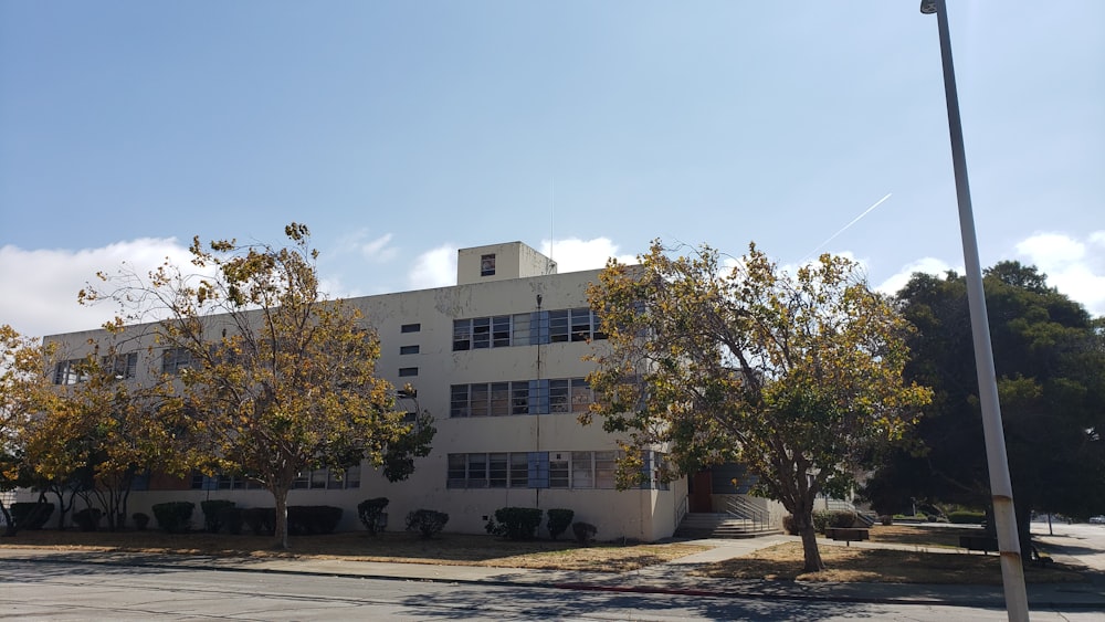 a white building with trees in front of it