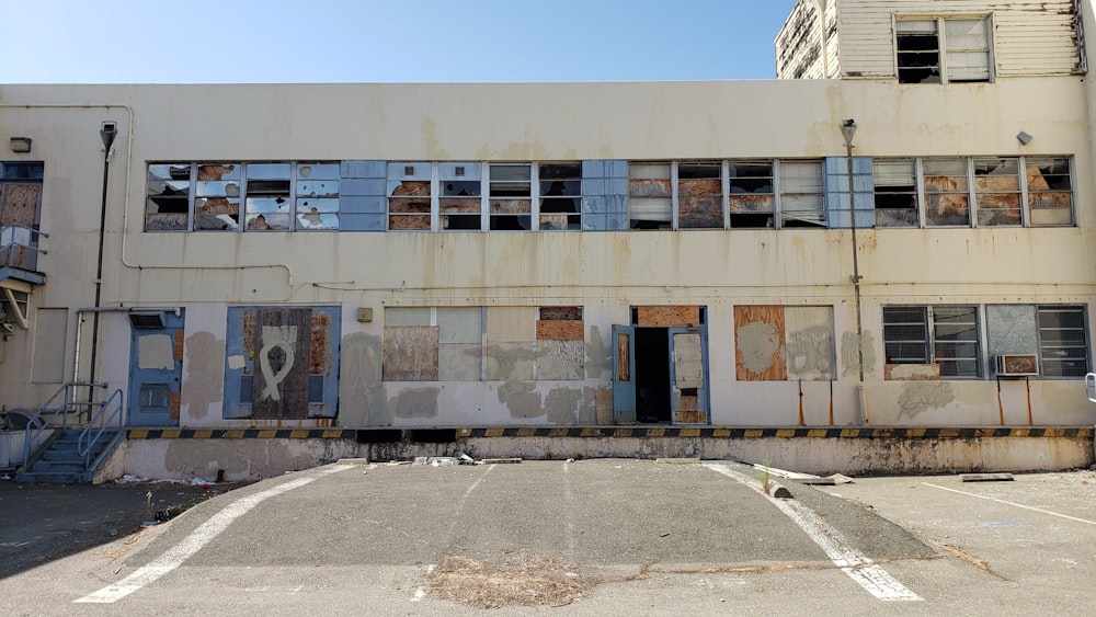 a run down building with a parking lot in front of it