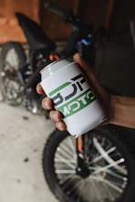a person holding a can of beer in their hand