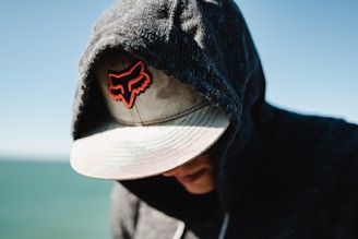 a man wearing a hat with a red fox embroidered on it
