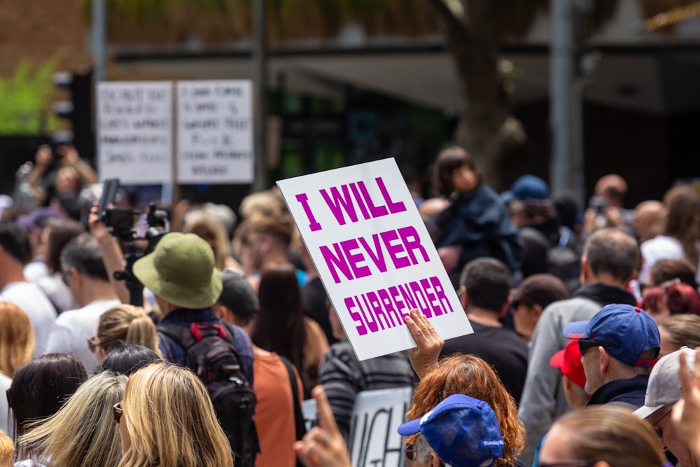 a crowd of people holding up signs in the air