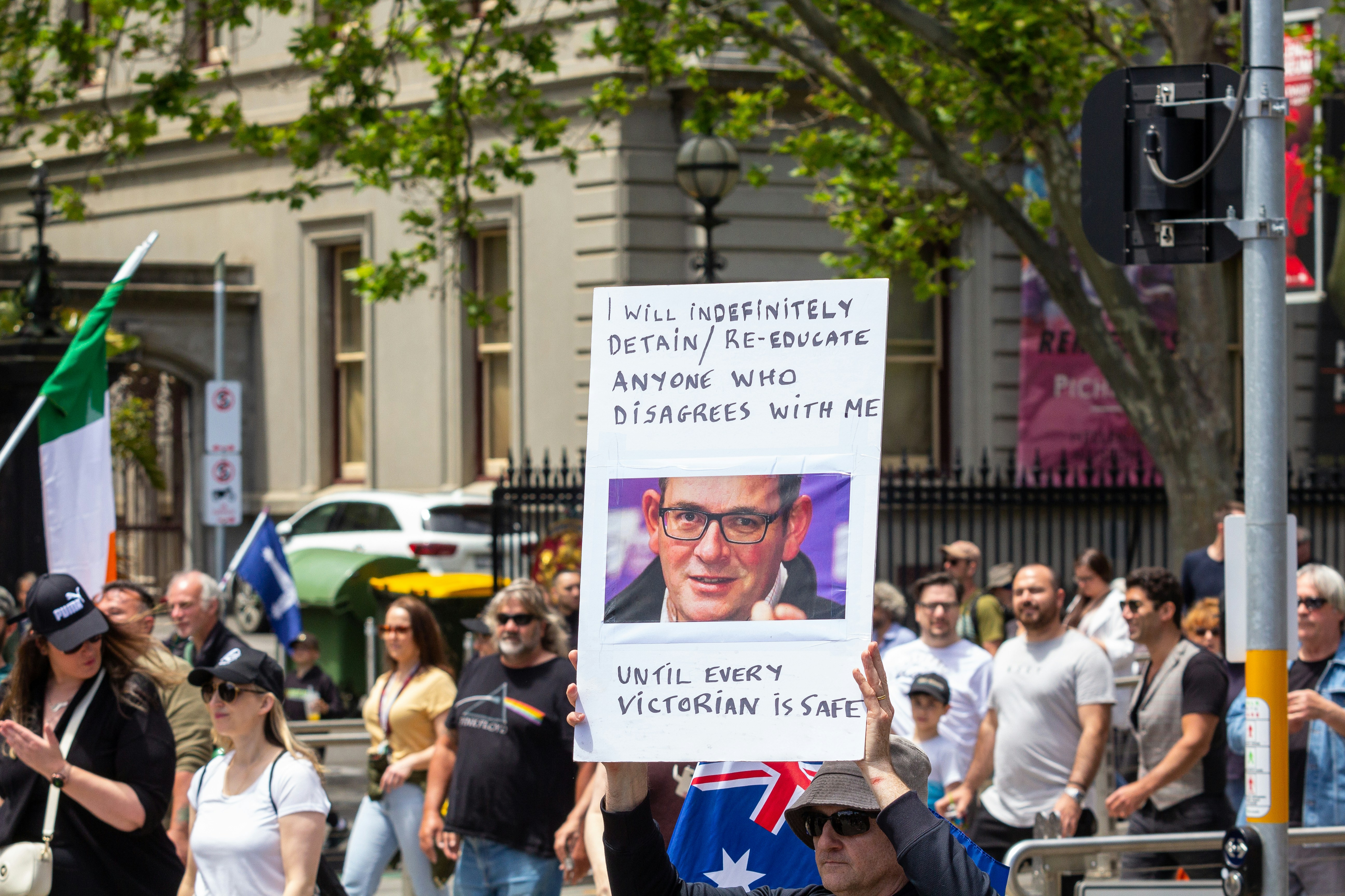 a man holding a sign with a picture of a man on it