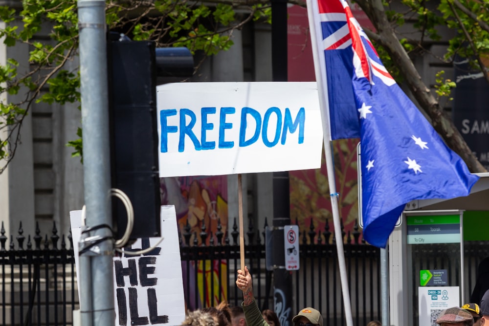 a group of people holding flags and a sign