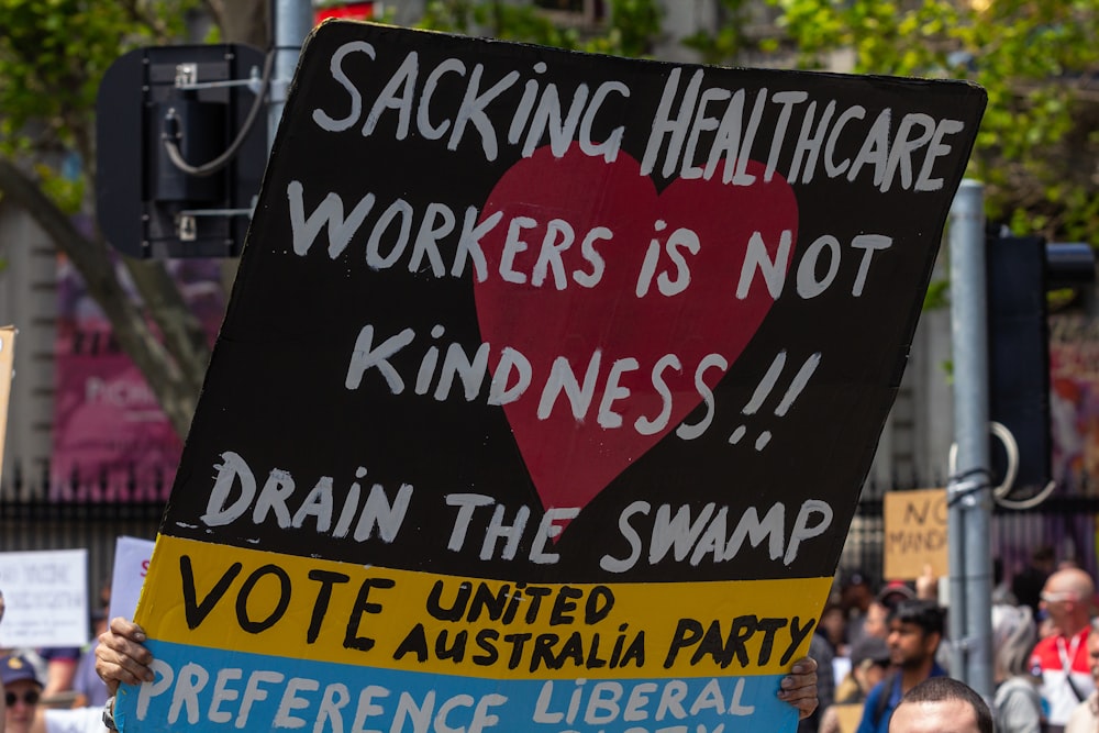 a person holding a sign with a heart on it