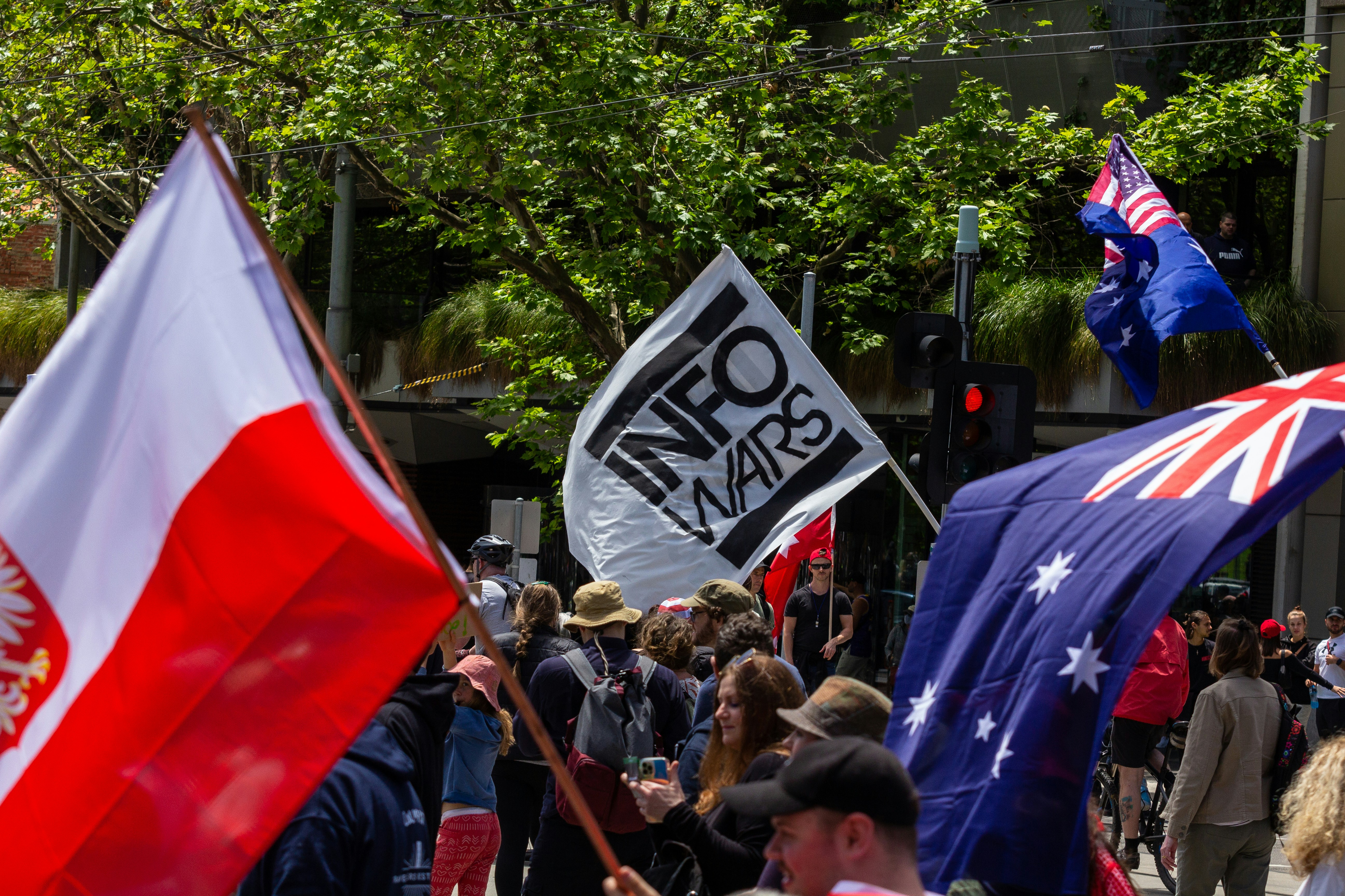 an info wars flag at A sign at Melbourne's Freedom protests rally and march in the city November 20th 2021 - over 200,000 people marched from Parliament to the Flagstaff Gardens. A happy family friendly crowd singing and chanting \