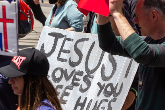 a group of people holding a sign that says jesus loves you etc