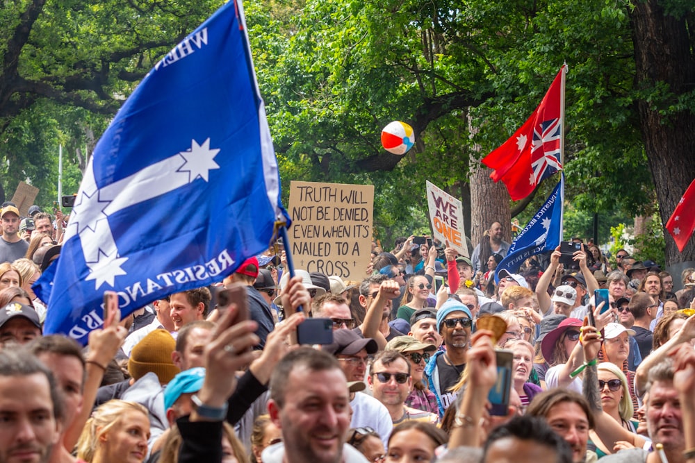 a crowd of people holding flags and signs