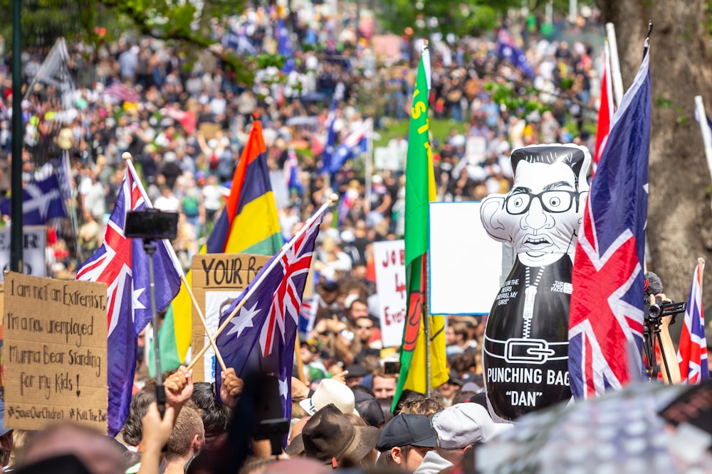 a large group of people holding flags and signs