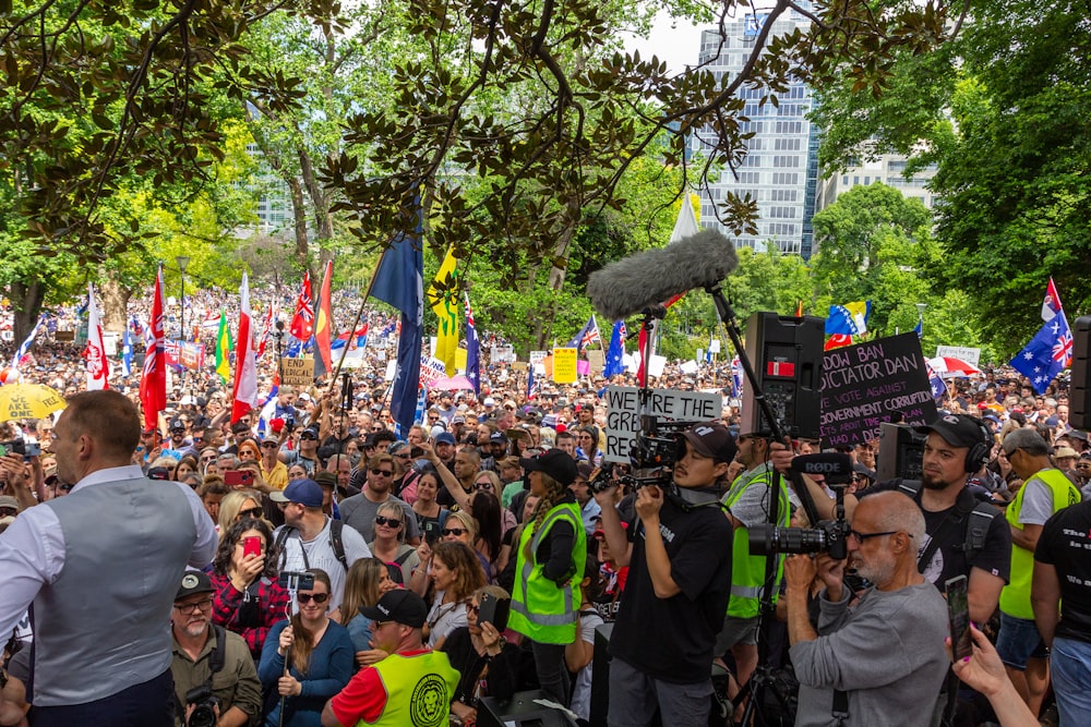 a large crowd of people holding signs and microphones