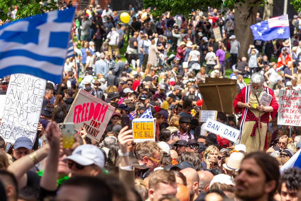 a large crowd of people holding signs and flags